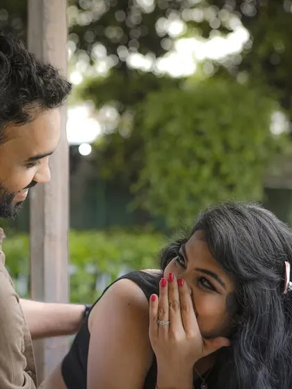 A playful and secretive moment during a pre-wedding shoot, capturing the fun and intimacy of the couple's relationship.