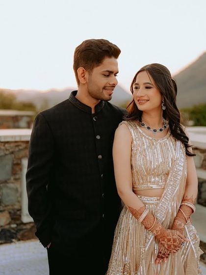 The couple looking at each other with love, with the beautiful Udaipur landscape providing a stunning backdrop.