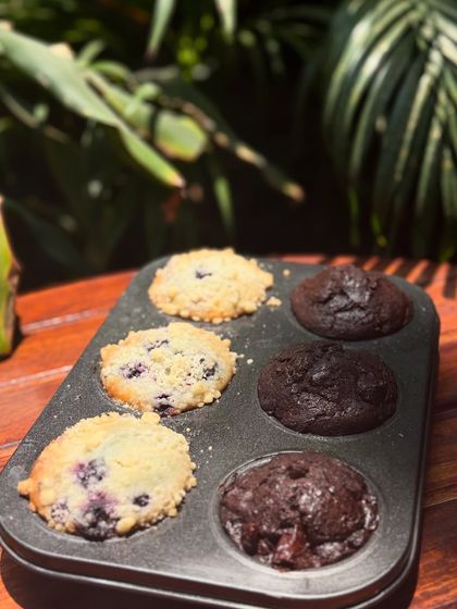 A closer look at my freshly baked muffins, still warm in the tin. You can see the juicy blueberries and rich chocolate chips in every bite.