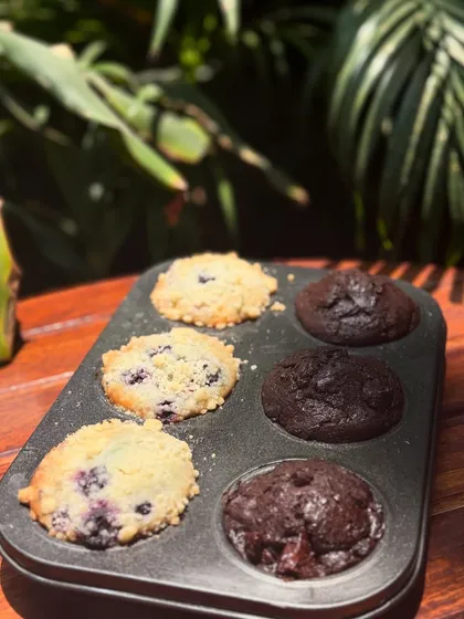 A closer look at my freshly baked muffins, still warm in the tin. You can see the juicy blueberries and rich chocolate chips in every bite.
