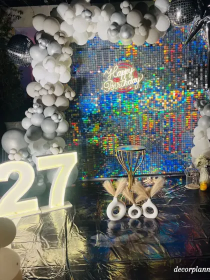 The lighting on this silver-themed setup is just magical. The marquee numbers for '27' glow beautifully against the sparkling backdrop, creating a captivating focal point for the celebration.