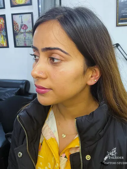This client chose a combination of a nostril stud and an earlobe piercing for a balanced look. I can perform multiple piercings in one session.