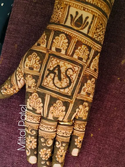 A personalized festive design featuring the couple's initials "AS" in a central block, surrounded by traditional Indian motifs.