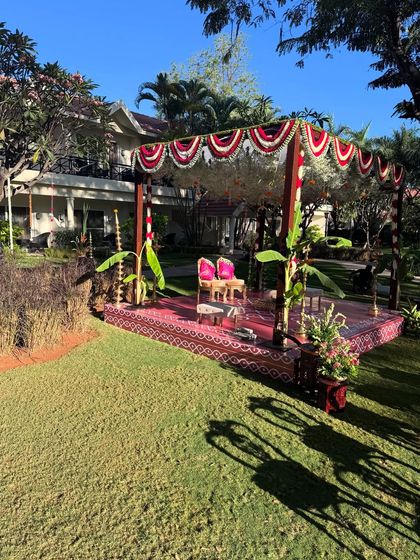 A wide shot of a traditional mandap setup for a Brahmin wedding. The decor features a beautiful blend of cultural elements and natural surroundings.