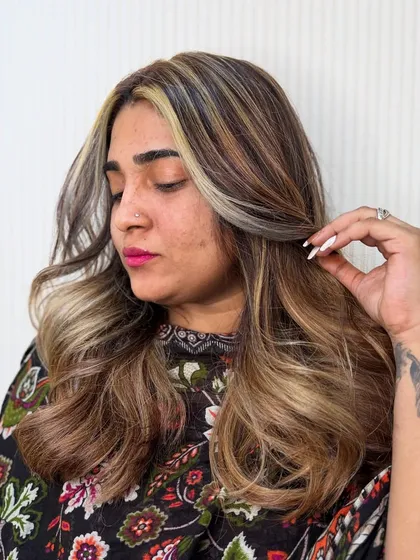 This client is rocking her new look, which includes a bold blonde "money piece" to frame her face and make a statement.