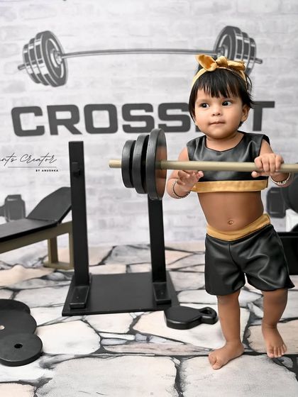 She's got the power! This shot captures the determination and cuteness of our little weightlifter as she prepares for a big lift.
