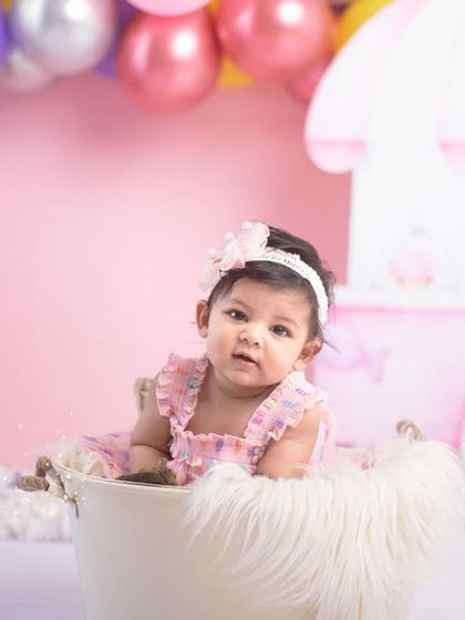Halfway to one! This little girl is enjoying her Candyland themed sitter session, nestled in a bucket with a soft fur blanket. These sessions are perfect for capturing that proud-to-be-sitting-up stage.