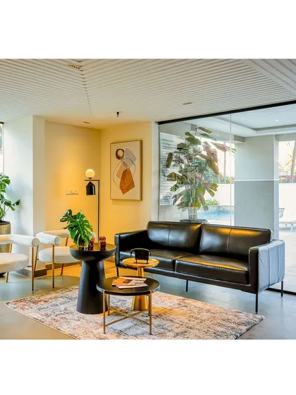 Another view of the lounge area, which overlooks the outdoor pool deck through a large glass wall, seamlessly connecting the indoor and outdoor spaces.