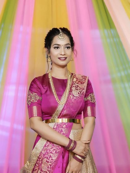 A simple and elegant half-up hairstyle with a traditional maang tikka.