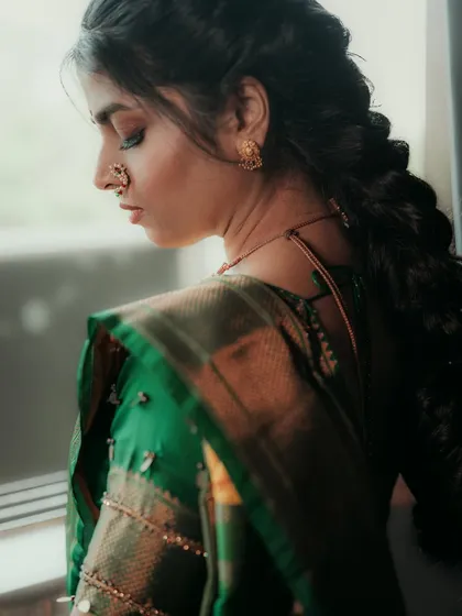 A side profile showing the bride's braided hairstyle and soft, natural makeup.