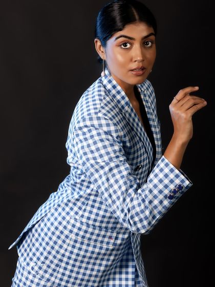 A dynamic pose with a turn towards the camera. The movement adds energy to the shot, while the gingham pattern provides a strong graphic element.