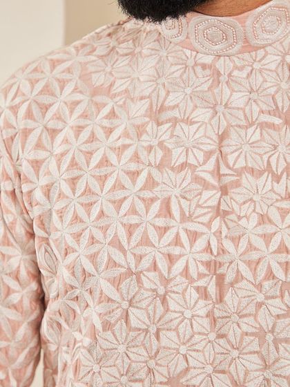 A macro shot of the geometric floral crewelwork embroidery on our blush pink kurta.