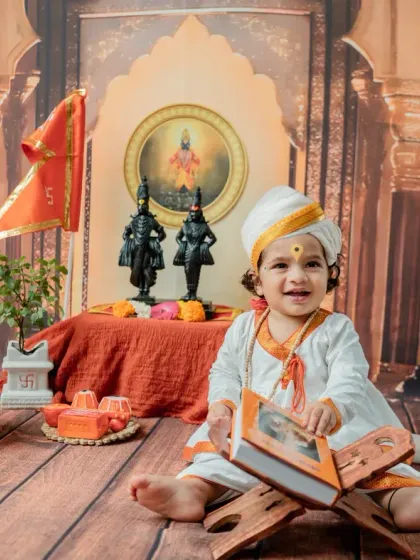 A bright, cheerful smile from the little Varkari, holding the book open. This shot perfectly captures the blend of tradition and childhood innocence.