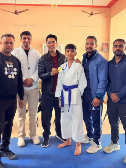 This young champion in his karate gi, holding his medal. His focus and determination are what set him apart.