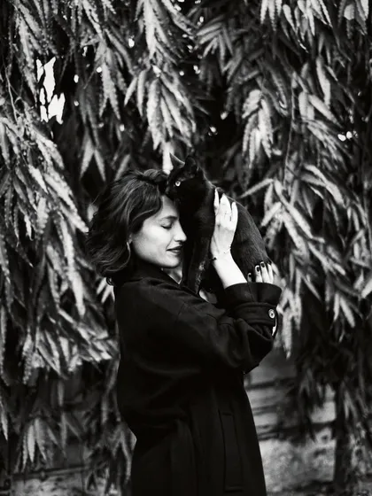A tender moment between a woman and a cat. Black and white photography enhances the feeling of quiet connection and the simple joy found in these chance encounters.