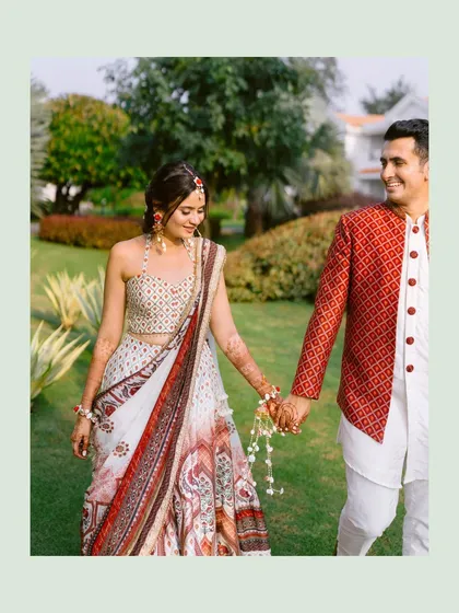A candid moment of the couple walking hand-in-hand through the resort gardens, sharing a smile and a quiet connection.