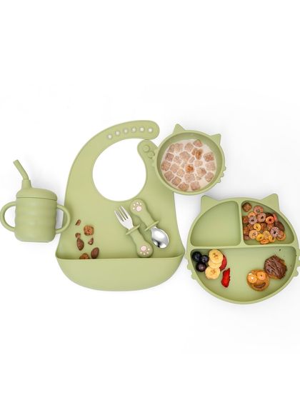 A flat-lay of a complete cat-themed dining set for kids, styled with cereals and fruits. This shows the entire product system in a fun and organized way.