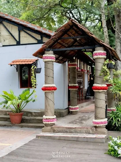 The entrance to a cottage, with its pillars wrapped in flowers, a simple touch that adds a festive feel.