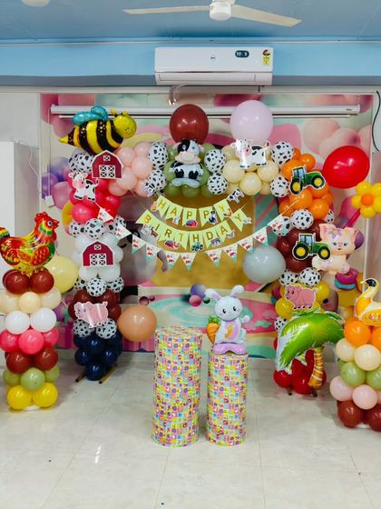 A classic farm animal theme, perfect for younger children. This setup includes balloon sculptures of a cow, pig, and chicken, along with a barnyard backdrop.