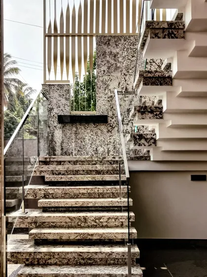 God is in the details. This exterior staircase for the 'House Reversed' project in Hassan showcases my passion for materials, featuring Bianco and Blue Pearl granite steps with a modern glass handrail for a truly luxurious entrance.