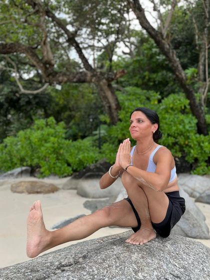 Balance means doing enough, not doing it all. A balancing squat on a rock by the sea.