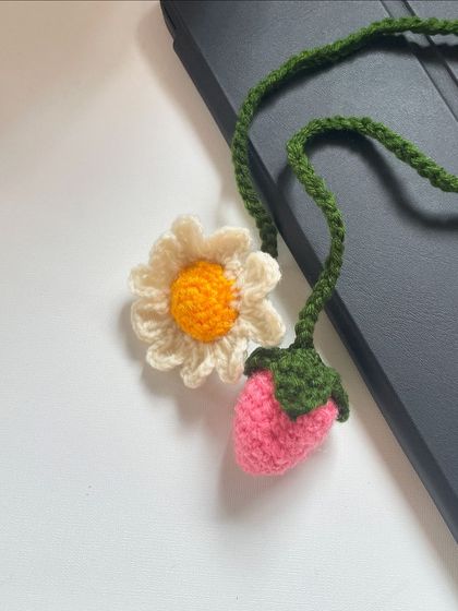 A whimsical combination of a daisy and a strawberry, this bag charm is a unique and playful accessory for anyone who loves cute, handmade items.