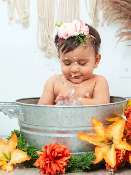 A playful moment as a baby splashes water during her bath session. These action shots are full of life and energy.