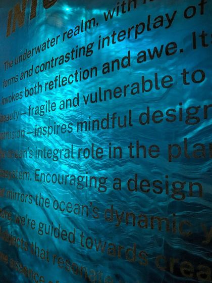 A close-up of the 'Into The Deep' narrative, embossed on a surface that mimics the movement of water. This detail shows our effort to integrate storytelling into every material and texture of the experience.