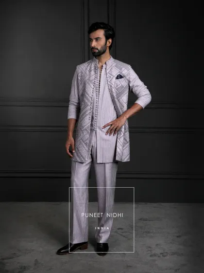 Not just attire, but artistry. A sequence blush pink kurta with loop buttons, straight tailored lines, and the regal touch of a mandarin collar, layered with a geometric jacket.