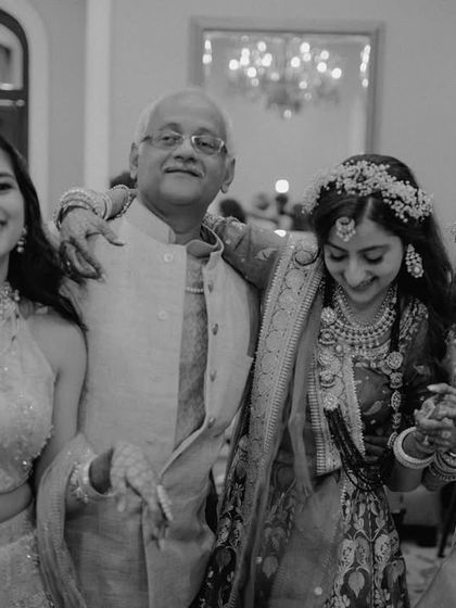 A beautiful family moment, with the bride, her sister, and mother all sharing a dance with their father. This photo is a snapshot of pure family joy and togetherness.