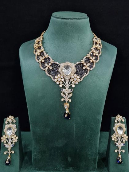 A beautiful bridal necklace set with a large central stone and intricate black and white detailing. This is a unique and elegant choice for a modern bride's reception.
