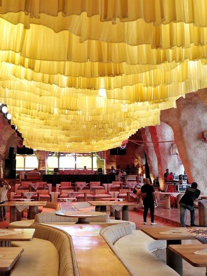 This photo shows the "before" of a ceiling transformation. The simple yellow fabric waves were the base layer for a much more intricate design, demonstrating how we build our installations in stages to achieve a final, spectacular look.