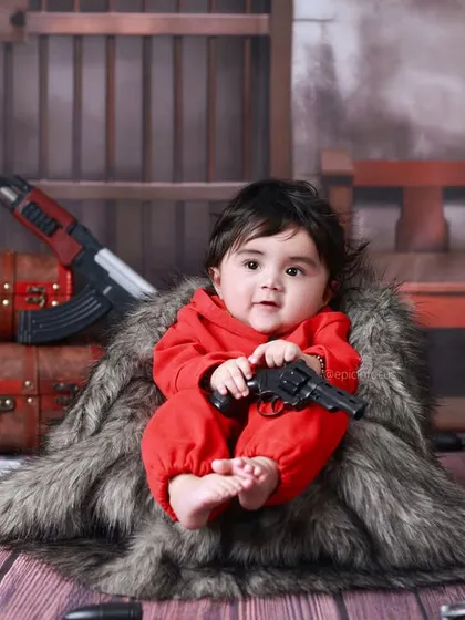 Holding a toy gun, this baby is fully in character. We ensure all props are safe and fun for children to interact with during the shoot.