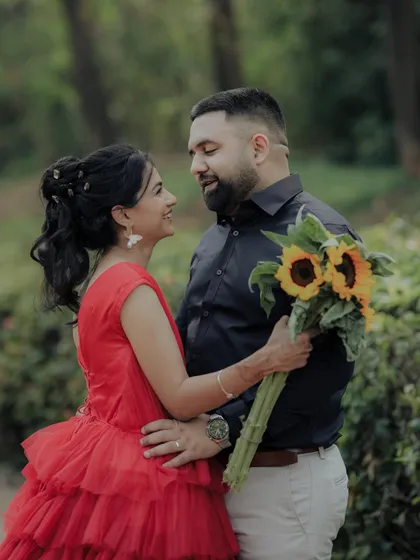An intimate embrace in a lush Pune garden. The soft focus and natural light enhance the romantic and heartfelt nature of this candid engagement photo.