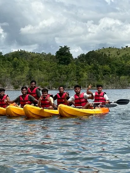 A group of friends gathers their kayaks together for a photo opportunity on the water.