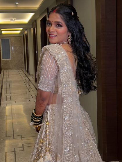 The bride looking back with a smile, showing off her beautiful open hairstyle for the reception.