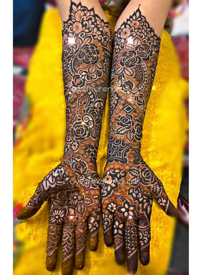 A complete bridal henna look, showcasing the level of detail and coverage I love to provide. This design features a dense mix of traditional Indian motifs, including paisleys and florals, extending up to the elbows for a truly grand statement.