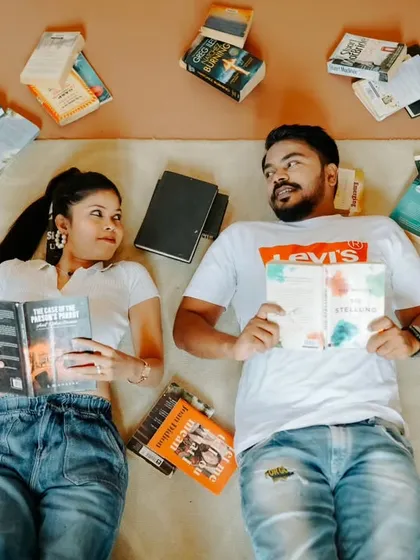 An artistic flat-lay portrait of the couple surrounded by their favorite books. This creative shot is a fun and unique way to celebrate a shared interest.