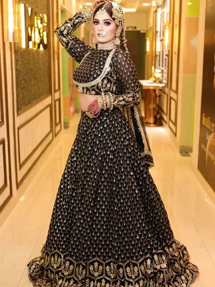 The full-length view of this black and gold lehenga shows its impressive silhouette. The high-neck blouse and detailed skirt make it a true statement piece.