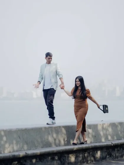 A fun, candid moment of the couple balancing and walking along the sea-link wall in Mumbai. It's all about capturing your unique dynamic.