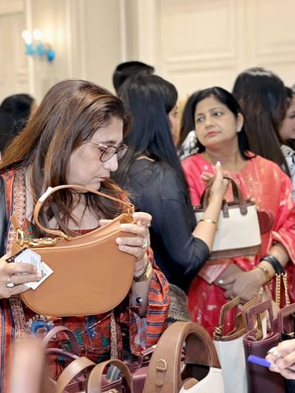 A guest browses a collection of handbags at a pop-up stall during my Mother's Day event. I partner with select brands to offer curated shopping experiences that add another layer of enjoyment to my social gatherings.