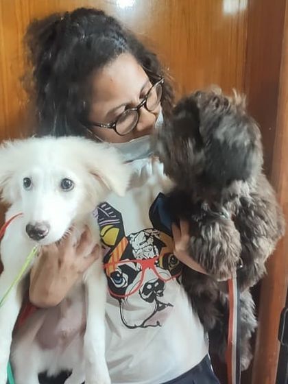 A student holding two puppies of different breeds, showing the diversity of dogs we work with in our courses.