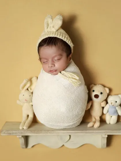 A slightly different angle of the potato sack pose, showing the baby's cute profile and bunny hat.