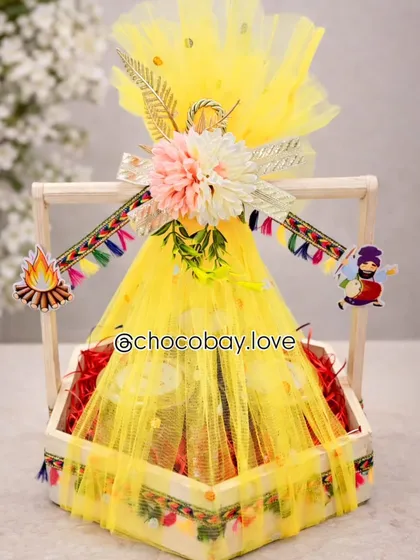 I love bringing festive traditions to life. This bright yellow Lohri hamper is packed with seasonal favorites like gajak and rewari, and decorated with traditional Punjabi motifs to capture the spirit of the harvest festival.