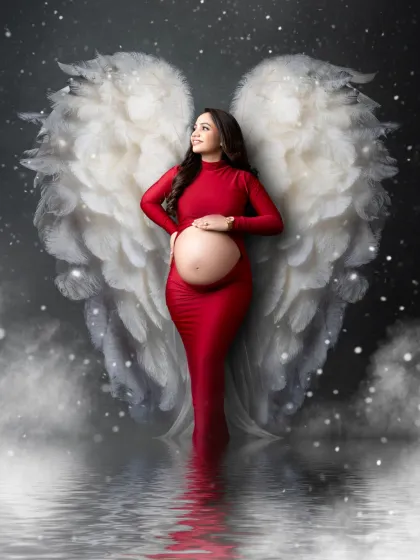 A heavenly portrait for a mother-to-be. We combined a gorgeous red gown with our angel wing prop and a dreamy, cloud-like setting to create this magical image.