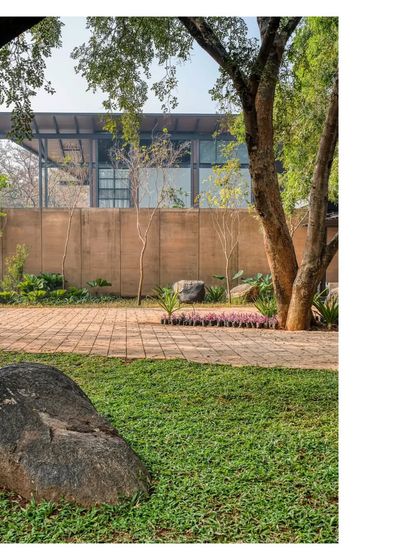 The home's earthen walls feel right in this landscape. The structure is seen here behind a large boulder, a permanent resident of the site that we chose to honor in our design.