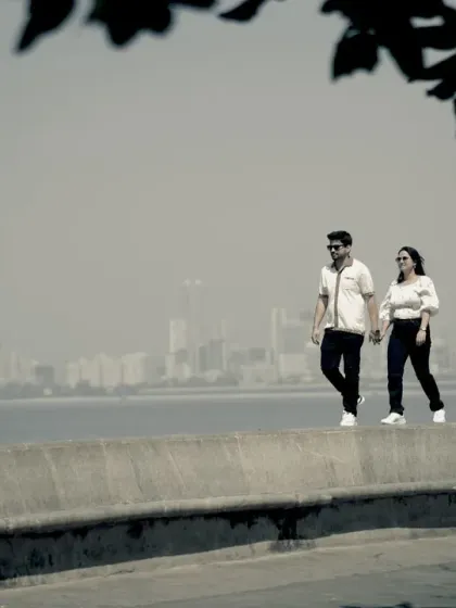 A casual stroll along Marine Drive for a pre-wedding shoot. The famous Queen's Necklace skyline provides a beautiful, hazy backdrop for relaxed and natural couple photos.