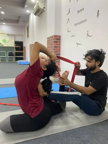 In our teacher training, I provide hands-on adjustments to help you find the correct alignment and deepen your postures safely. Here, I am assisting a student in Rajakapotasana (King Pigeon Pose) using a strap to gently open the shoulders and deepen the backbend.
