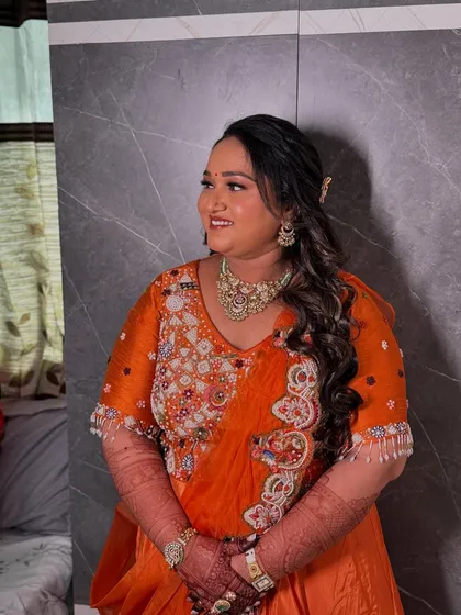 Looking absolutely beautiful and happy. Her hairstyle is a cascade of soft curls, keeping her comfortable yet elegant.