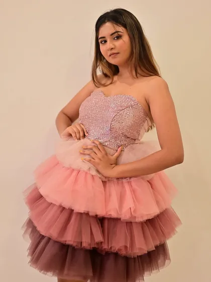 A confident pose showing off the full silhouette of the dress. The makeup adds to the overall sparkling, celebratory feel.